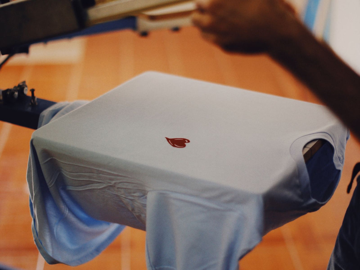 Peeling transfer film off a shirt to reveal a full-color DTF print